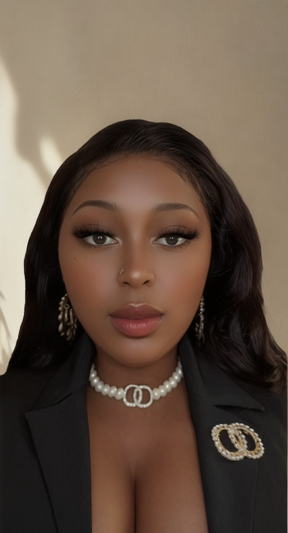 Kedeesh Nolan in black blazer and pearls
